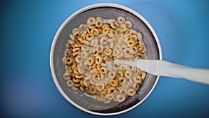 Pouring milk in honey cereals.