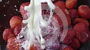 Pouring milk onto strawberries in slow motion