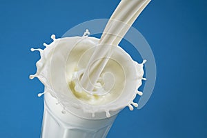 Pouring milk splash in glass, top view