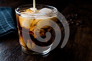 Pouring milk to iced coffee or cold brew.