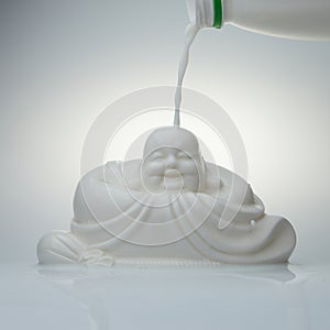 pouring milk on a white porcelain buddha statue