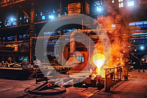 Pouring molten metal into mold from ladle container in foundry metallurgical factory workshop, iron cast, heavy