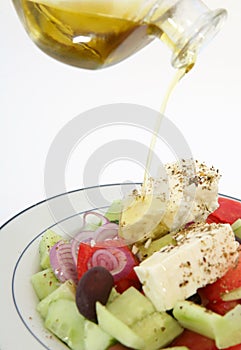 Pouring oil on Greek salad vertical