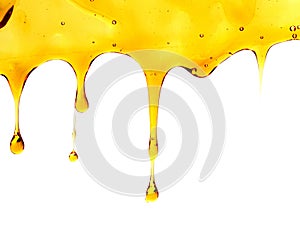 Pouring oil splash on spoon. Isolated on white background.