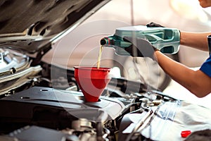 Pouring oil to car engine, Mechanic pouring oil into car