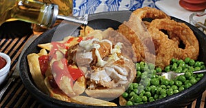 Pouring olive oil over an English fish and chips