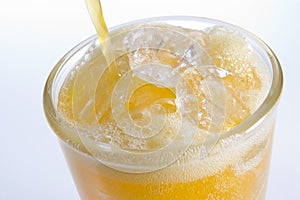 Pouring Orangeade Into A Glass Of Ice