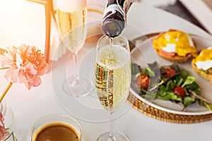 Pouring prosecco sparkling wine in a glass on sunday brunch photo