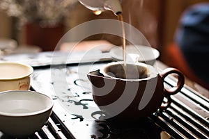 Pouring of Puer Tea from Teapot at Traditional Chinese Tea Ceremony. Set of Equipment for Drinking Tea