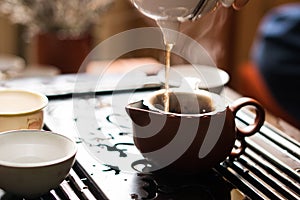 Pouring of Puer Tea from Teapot at Traditional Chinese Tea Ceremony. Set of Equipment for Drinking Tea