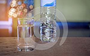 Pouring purified fresh drink water from bottle on glass table ba