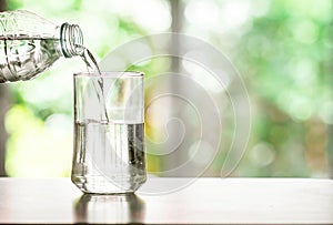 pouring purified fresh drink water from the bottle on table in