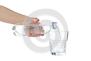 Pouring purified fresh water from the bottle in glass, isolated on background