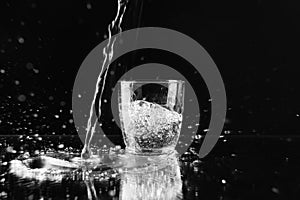 Pouring purified fresh water in glass on background