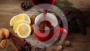 Pouring of red cup with mulled wine on festive table