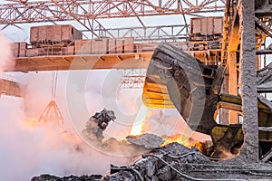 Pouring the red-hot melt by truck transporter with ladle