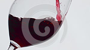 Pouring red liquid glass closeup. Gourmet alcoholic drink bubbled wineglass