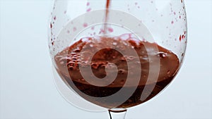 Pouring red wine of bottle. Isolated beverage, alcohol, winery footage on white background