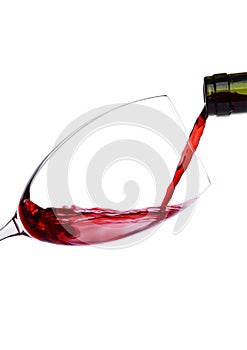 Pouring red wine from bottle to glass isolated