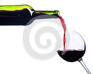 Pouring red wine from bottle to glass isolated on white