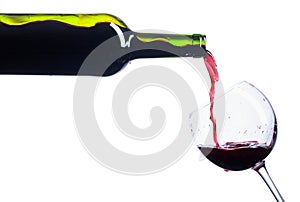 Pouring red wine from bottle to glass isolated on white