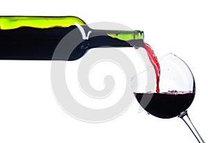 Pouring red wine from bottle to glass isolated on white