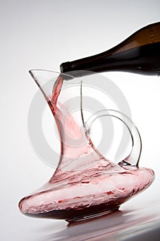 Pouring red wine into decanter photo
