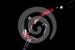 Pouring red wine glass black background