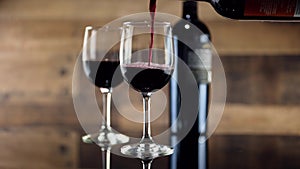Pouring red wine into glass on table at restaurant
