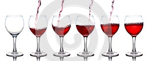 Pouring of red wine in a glasss isolated on white