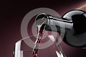Pouring red wine into a wineglass photo