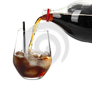 Pouring refreshing cola into glass with ice cubes