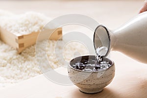 Pouring sake into a small Japanese cup