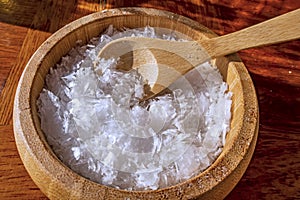 Pouring salt in wooden plate and wooden spoon