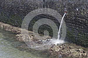 Pouring sewage water into the river.