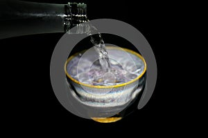 Pouring Shochu, Japanese distilled spirit, into guinomi or sake cup or earthen ware.