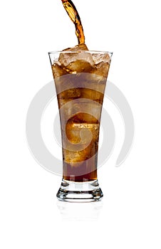 Pouring soda cola in a glass with ice on white