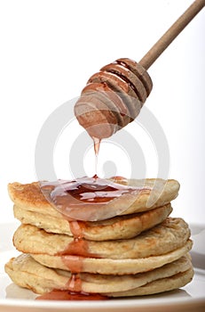 Pouring a stack of oatmeal with strawberry jam with a spindle