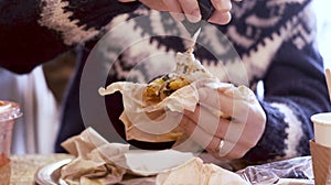 Pouring tahini onto his falafel sandwich