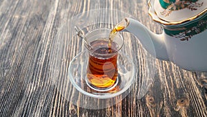 Pouring tea into a cup on a wooden table