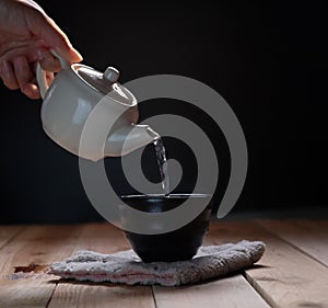 Pouring tea in teapot and cup