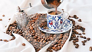 Pouring Turkish coffee into coffee cup on white background