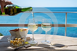 Pouring of txakoli or chacolÃ­ slightly sparkling very dry white wine produced in the Spanish Basque Country, served outdoor with