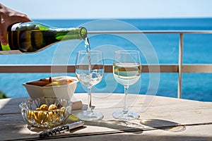 Pouring of txakoli or chacolÃ­ slightly sparkling very dry white wine produced in the Spanish Basque Country, served outdoor with