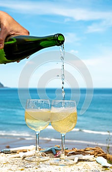 Pouring of txakoli or chacolÃ­ slightly sparkling very dry white wine produced in the Spanish Basque Country, served outdoor with