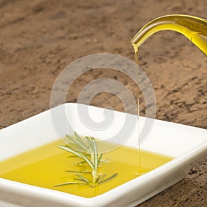 Pouring virgin olive oil in a plate