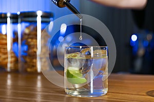 Pouring vodka into glass on counter in bar