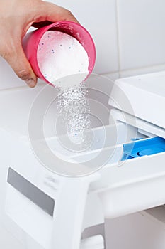 Pouring washing powder into the washing machine