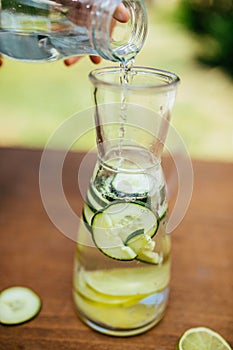Pouring Water In The Bottle With Cucumber