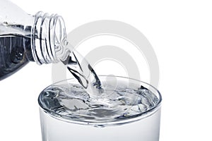 Pouring water from bottle into the glass with clipping path isolated on a white background